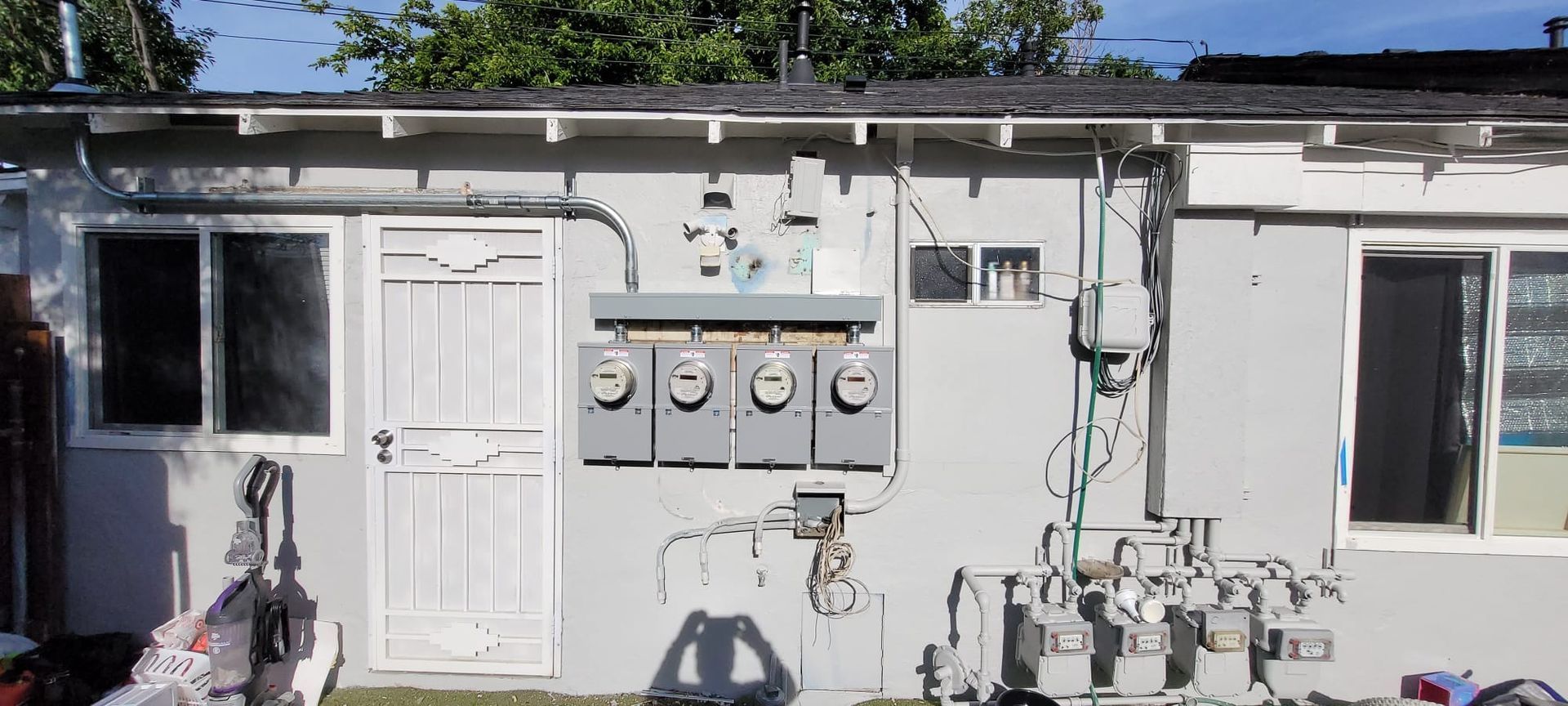 A white house with a lot of wires on the side of it.