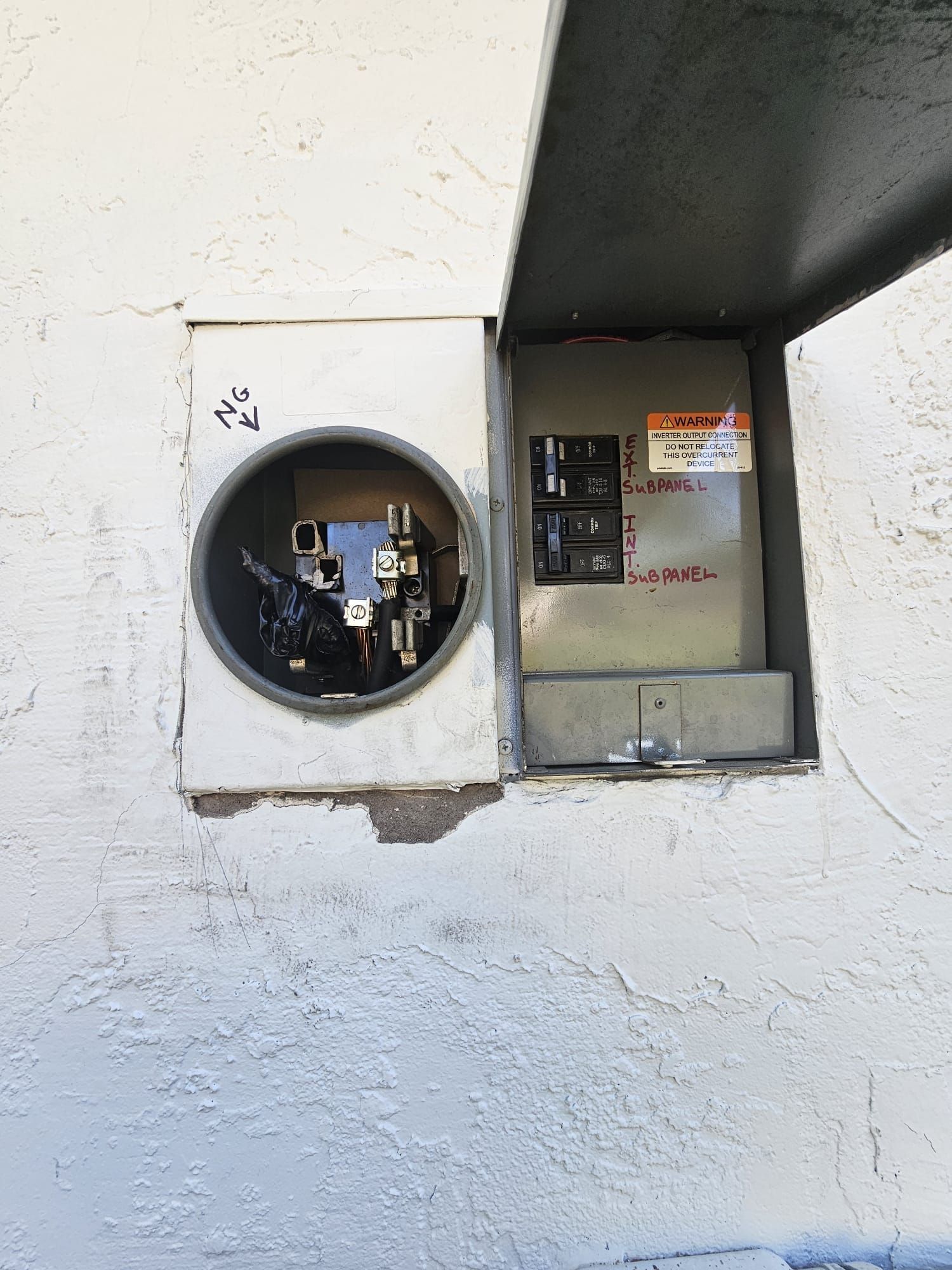 A round electrical box is sitting on a white wall.
