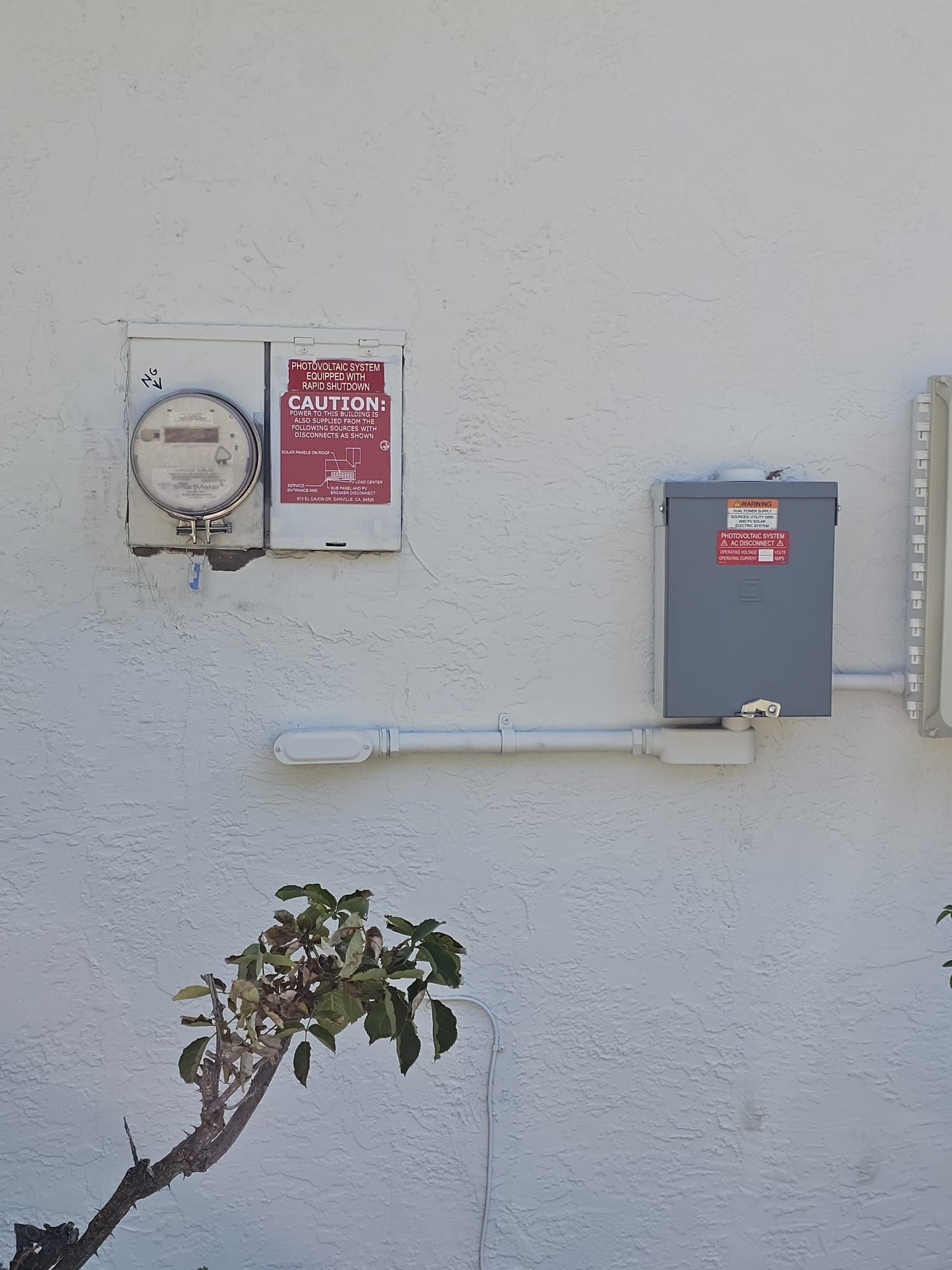 A white wall with a meter and a box on it