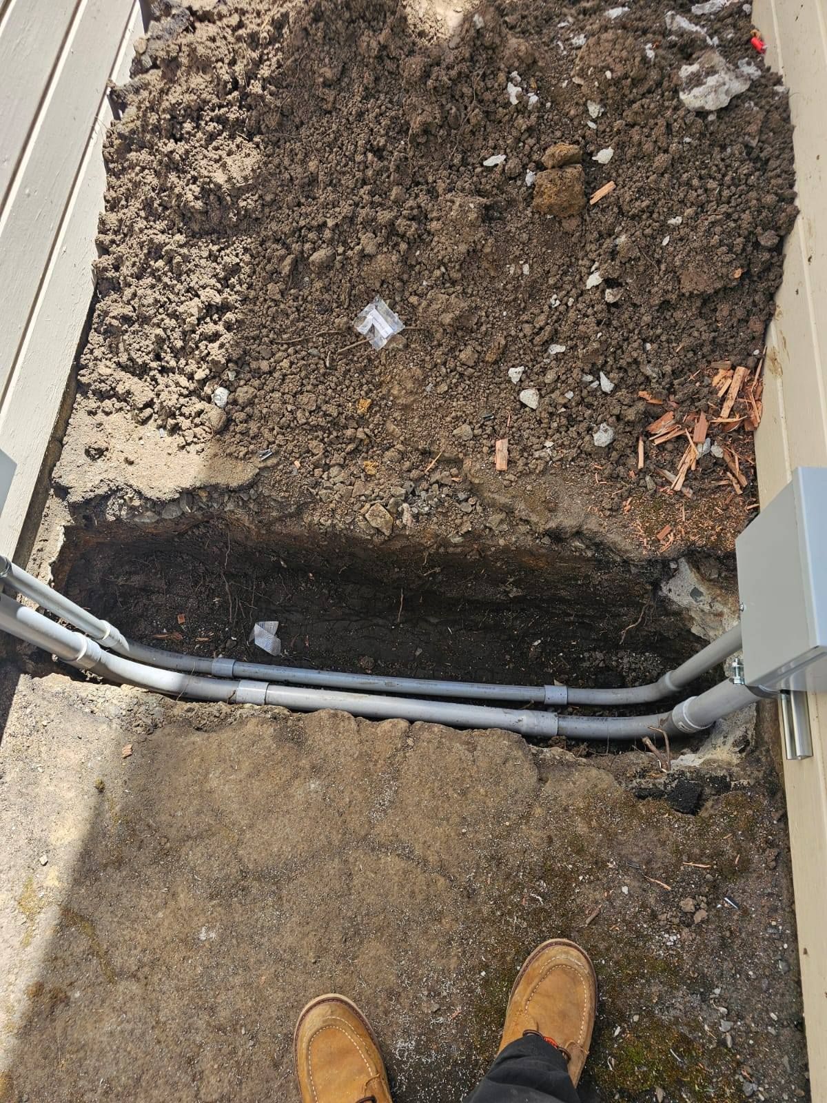 A person is standing next to a hole in the ground.