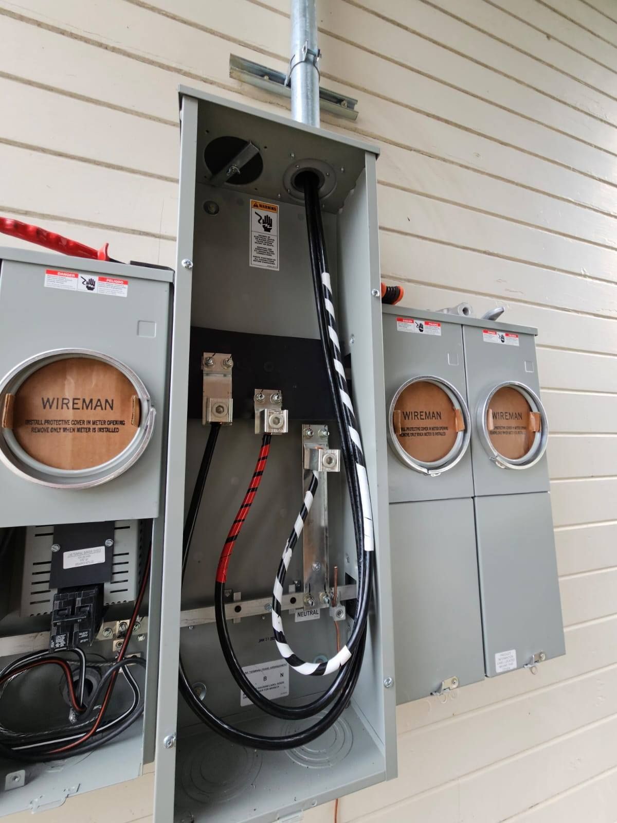 A close up of a electrical box with wires coming out of it.