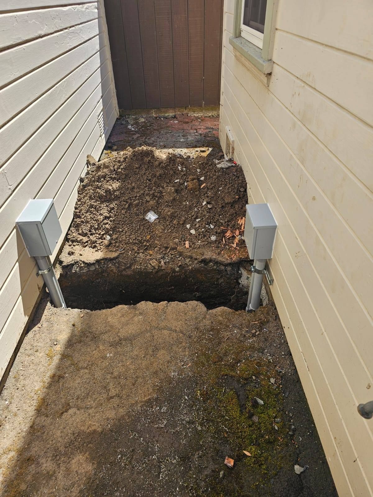 There is a hole in the ground in the side of a house.