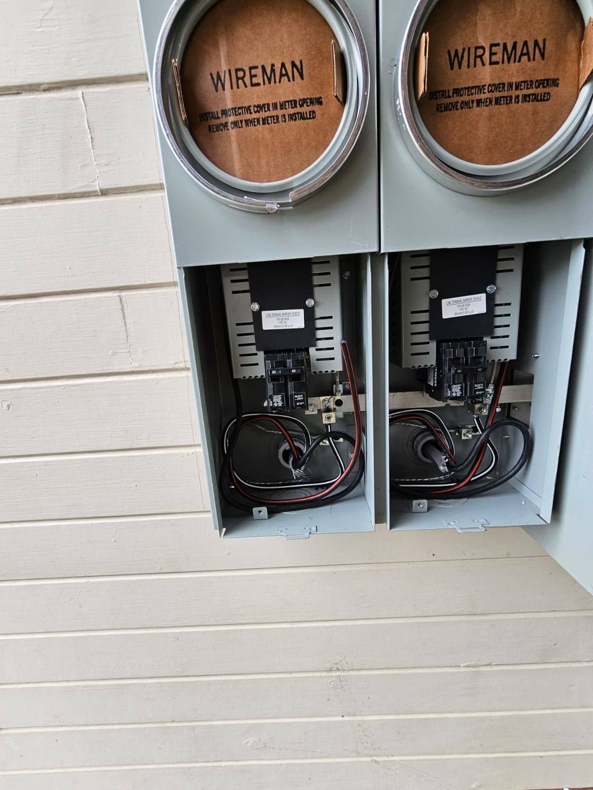 A couple of electrical boxes with wires coming out of them.