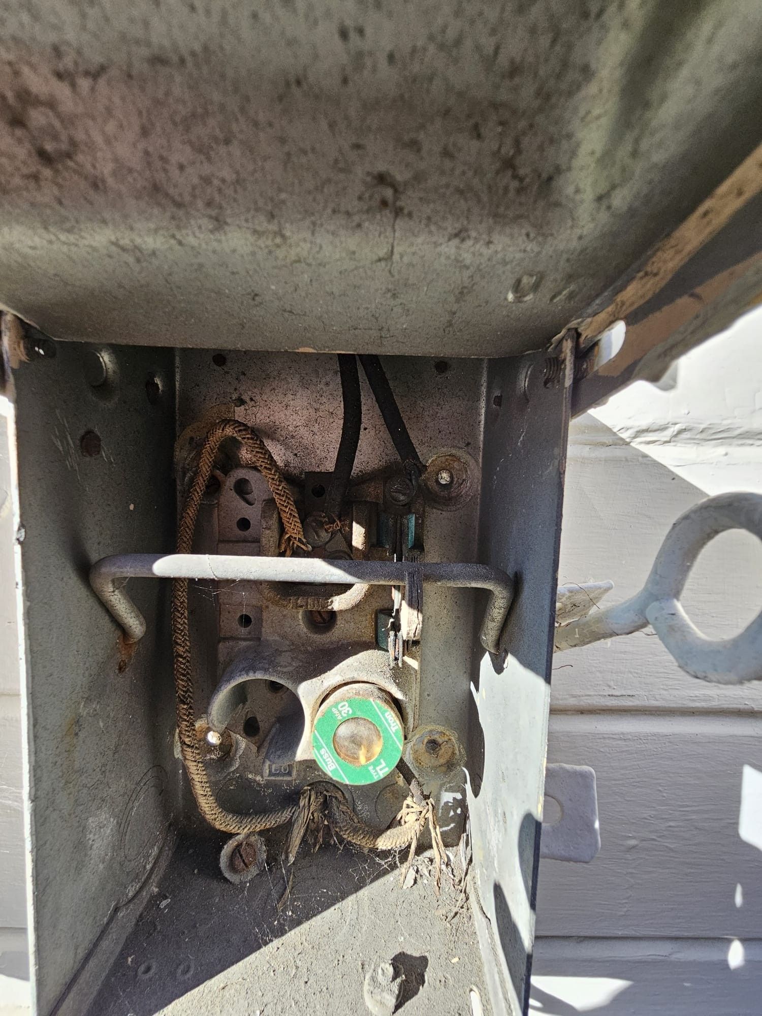 A close up of the inside of a metal box with wires coming out of it.