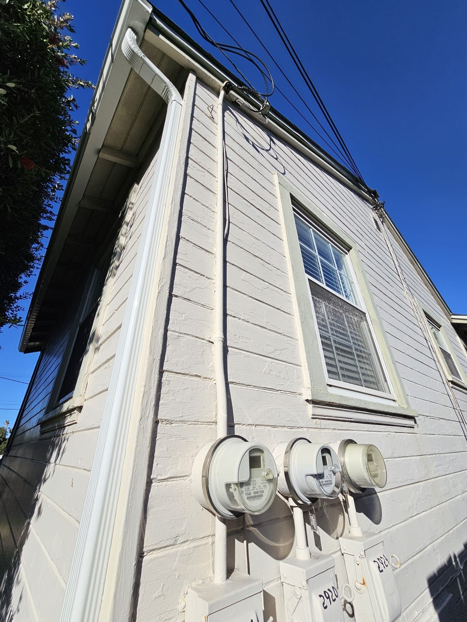 Looking up at a white house with a blue sky in the background