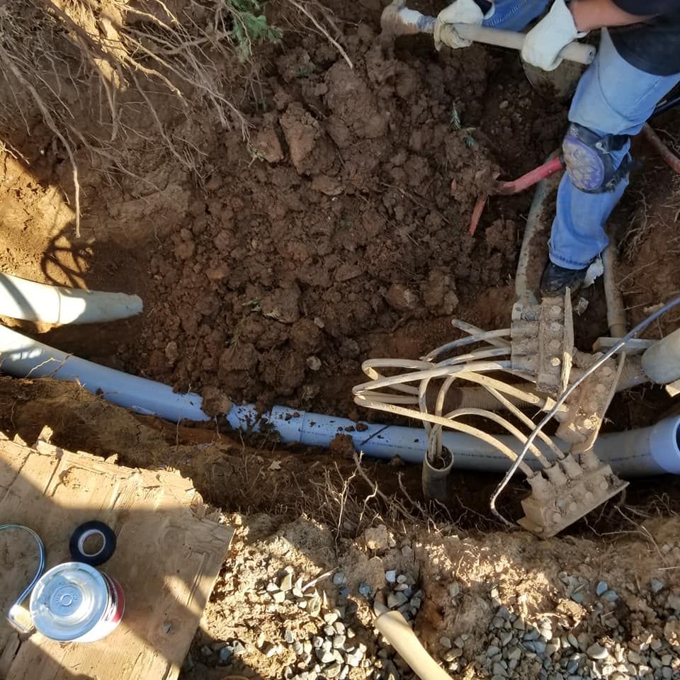 A man is digging in the dirt with a shovel