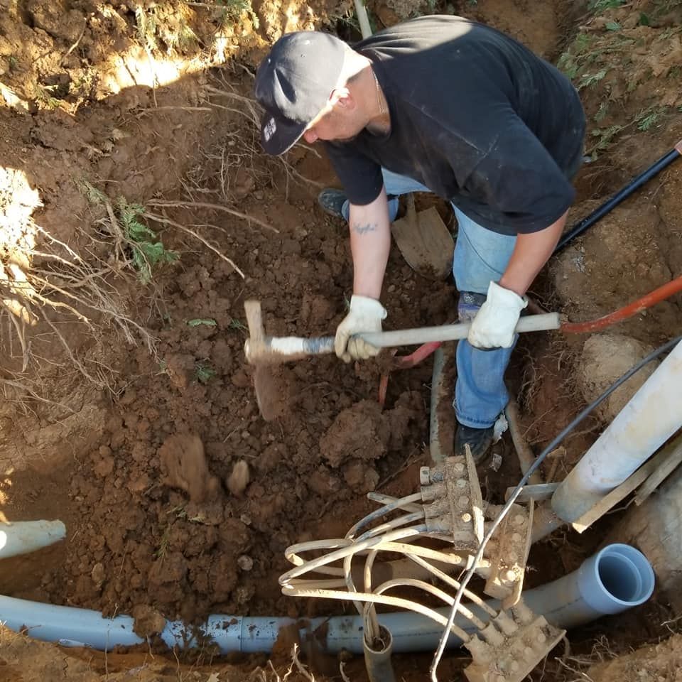 A man is digging in the dirt with a shovel