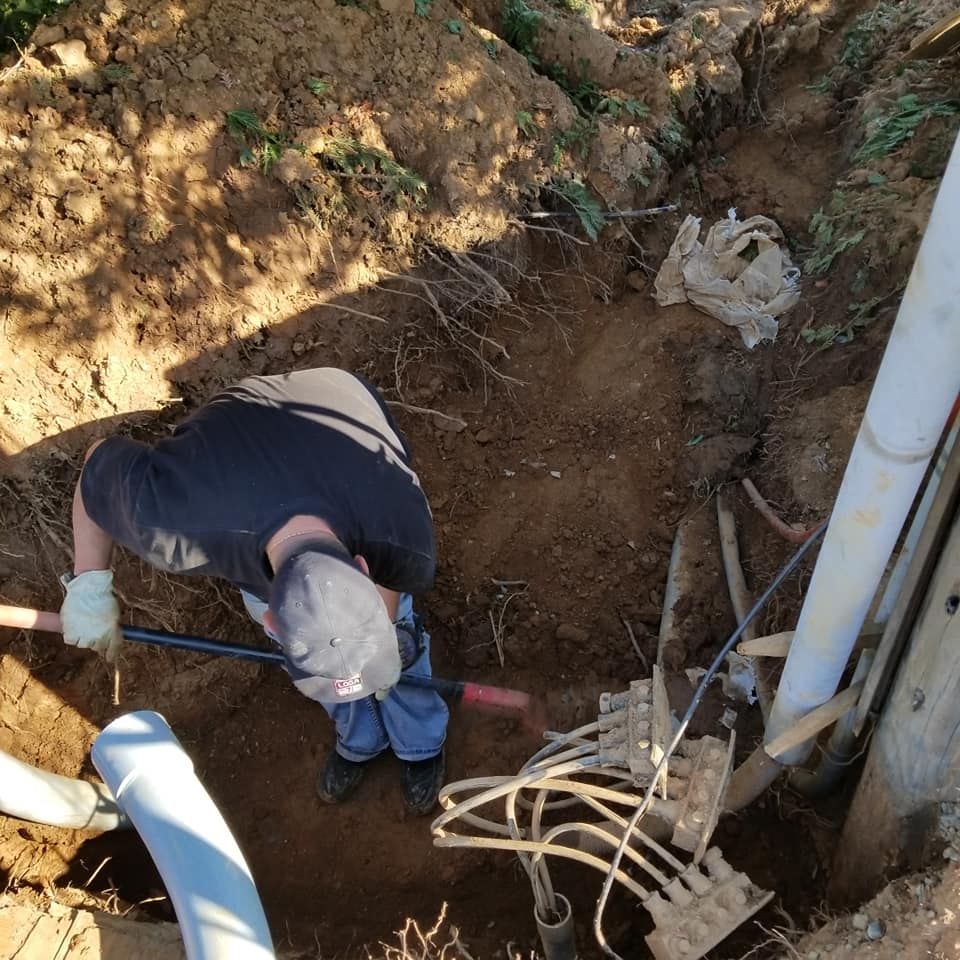 A man is digging a hole in the dirt with a shovel