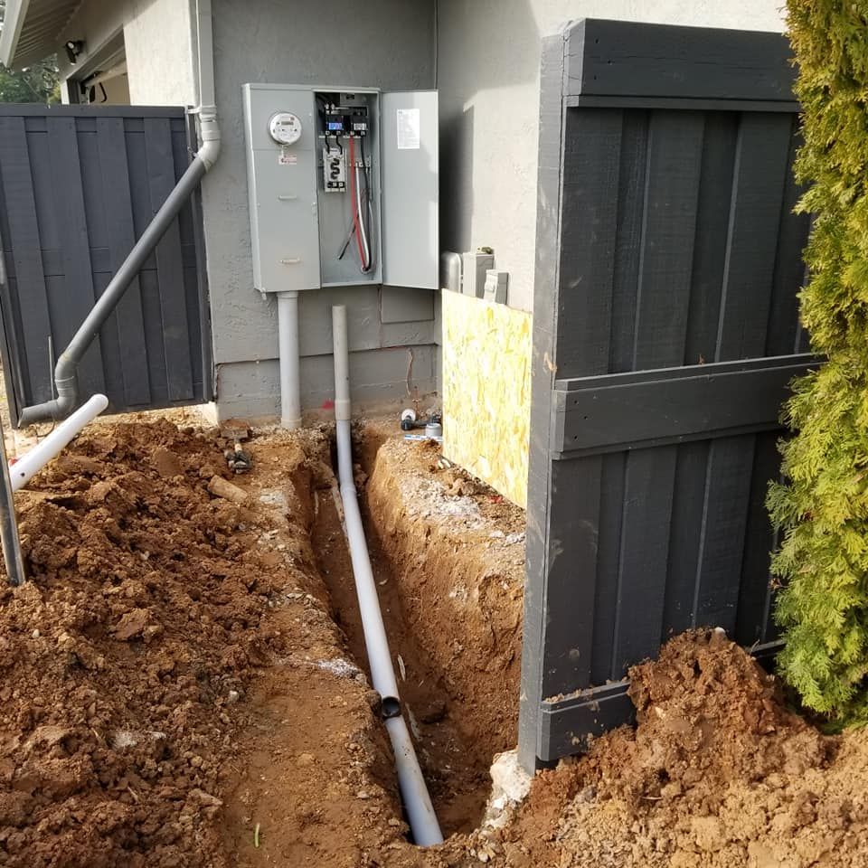 An electrical box is being installed on the side of a house