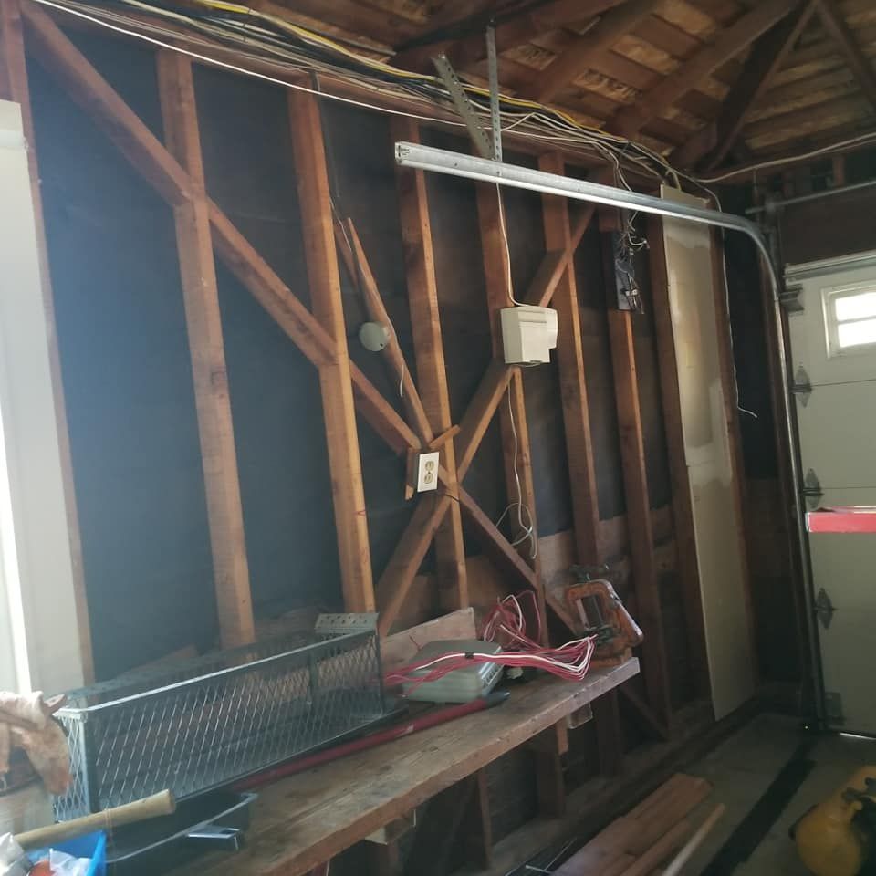 A garage with a wooden wall and a metal fence