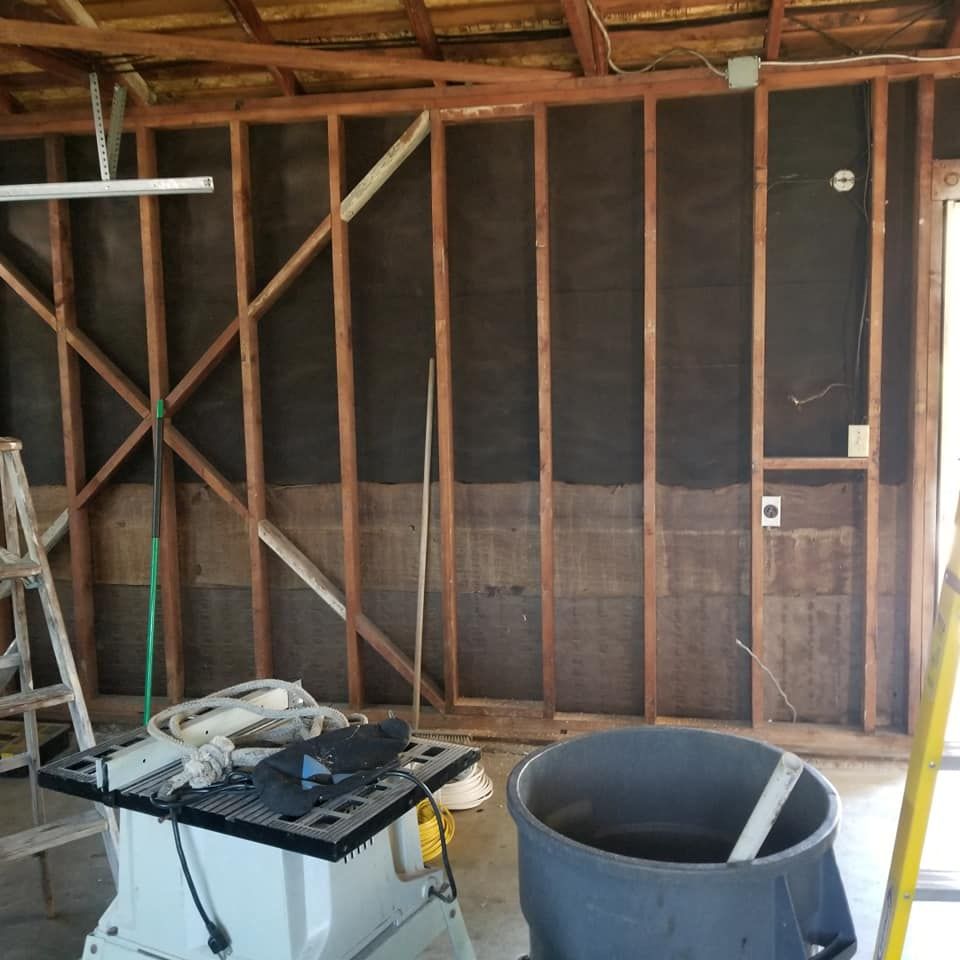 A room with a ladder and a bucket on the floor