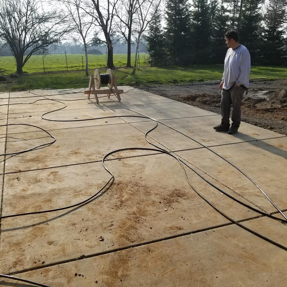 A man is standing on a concrete surface with a bunch of wires on it
