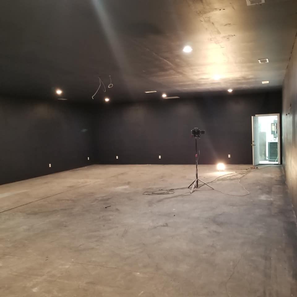 An empty room with black walls and a light on the floor