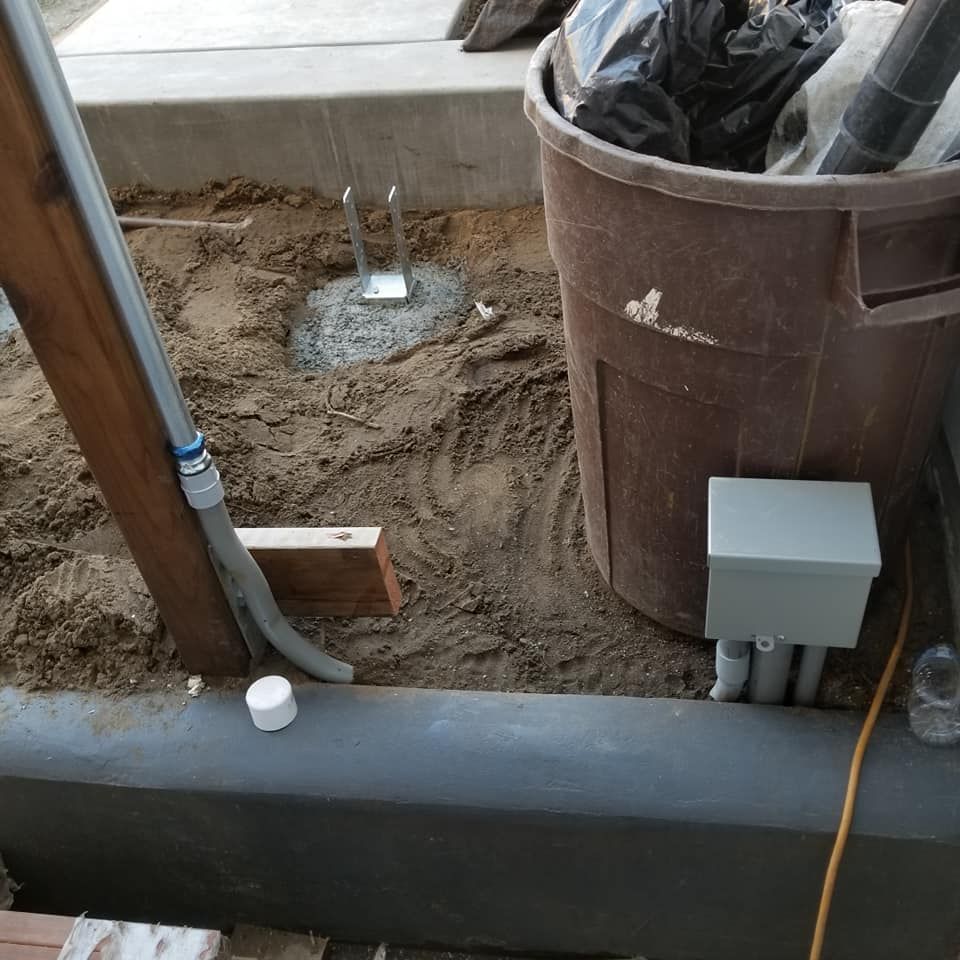 A trash can is sitting in the dirt next to a box