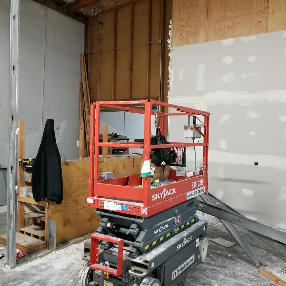 A red skyjack scissor lift is in a warehouse