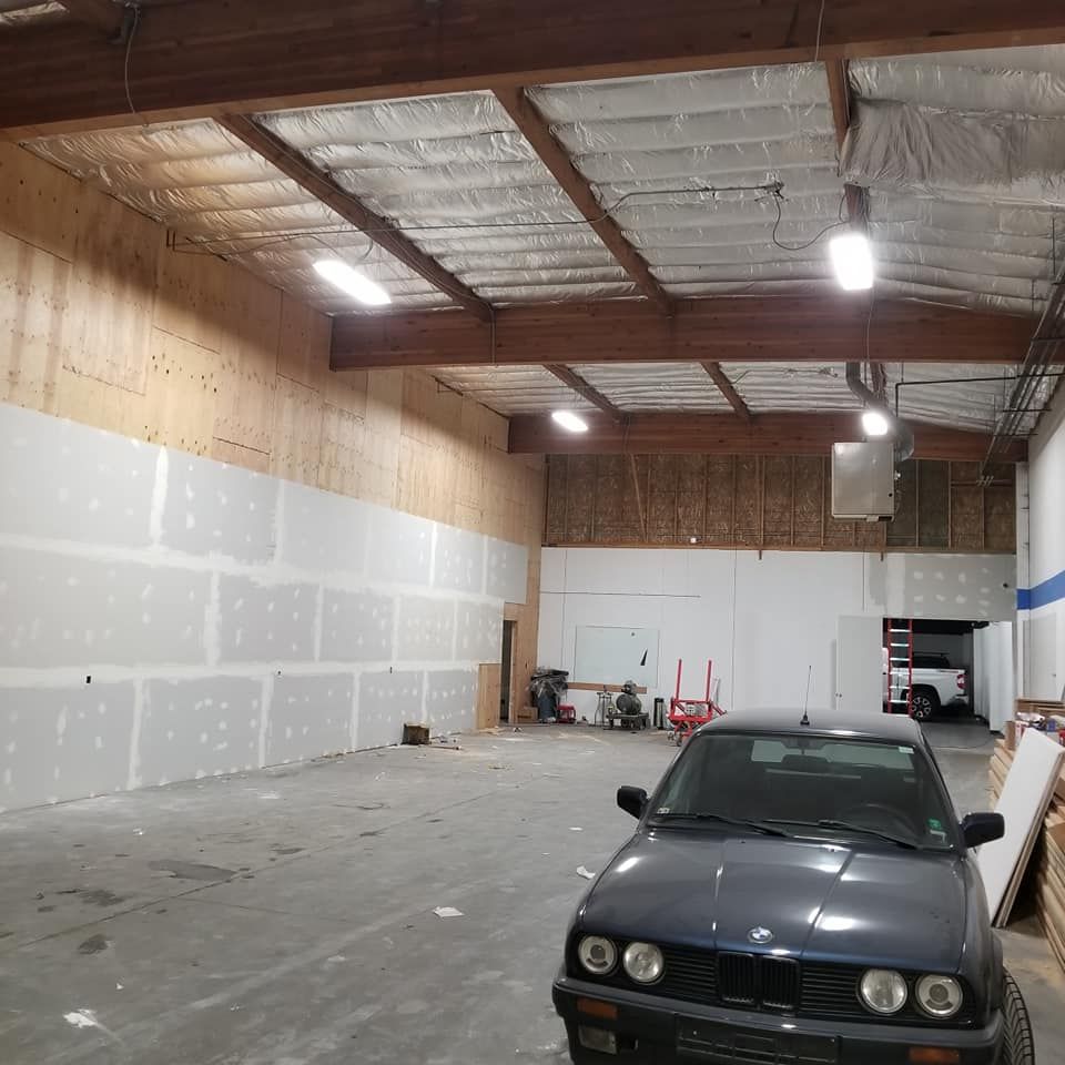 A car is parked inside of a large warehouse