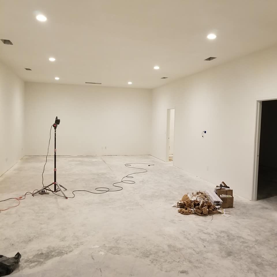 An empty room with white walls and a concrete floor