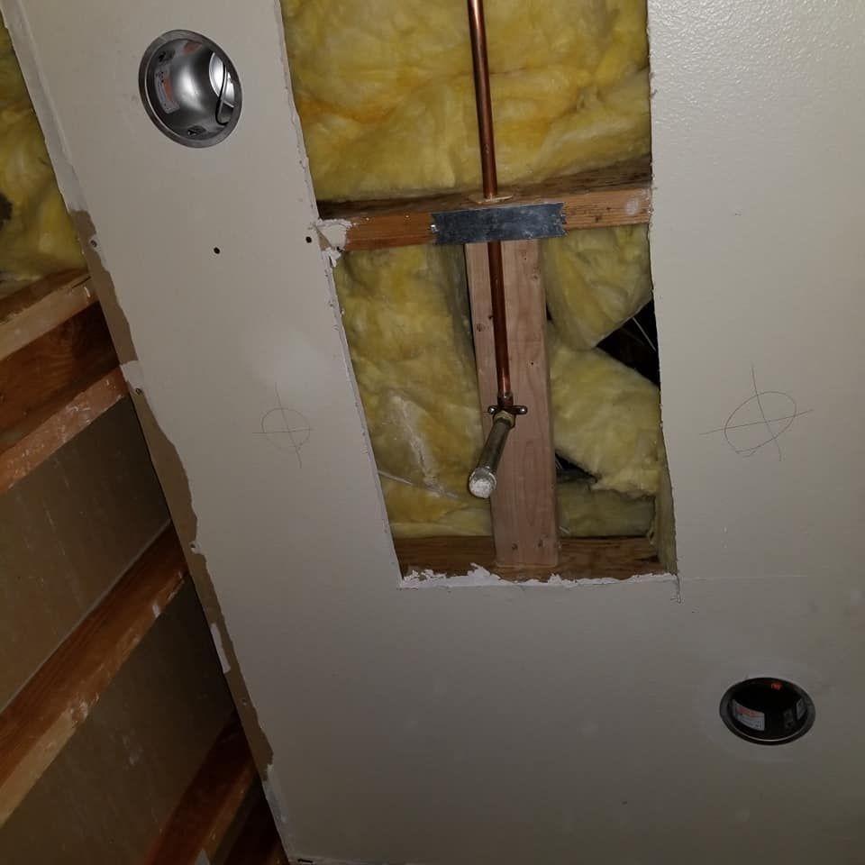 There is a hole in the ceiling with a pipe coming out of it.