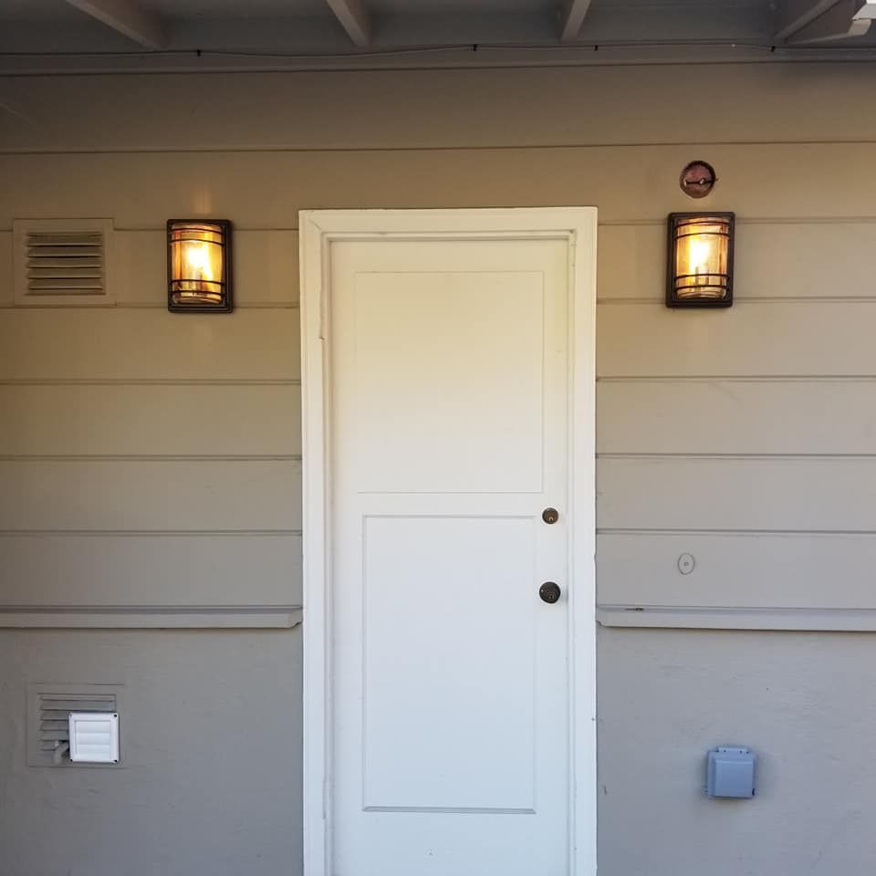 A white door with two lights on the side of it