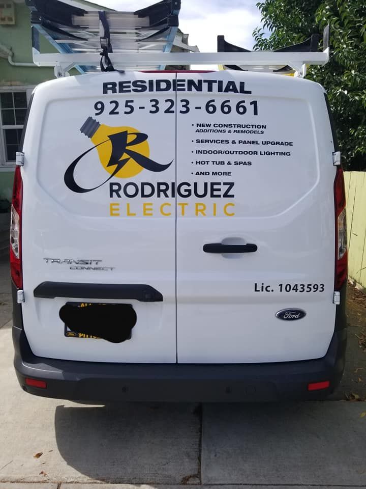 A residential rodriguez electric van is parked in a driveway