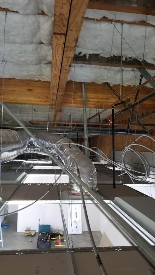 A ceiling with a lot of wires hanging from it.