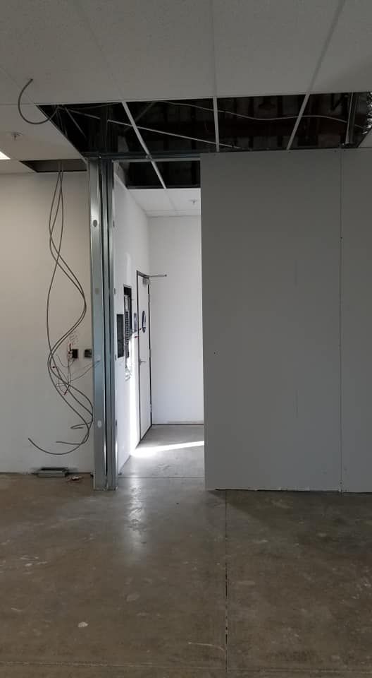 An empty room with a ceiling that is missing a piece of it.