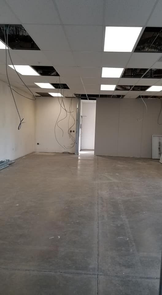 A large empty room with a concrete floor and ceiling lights.