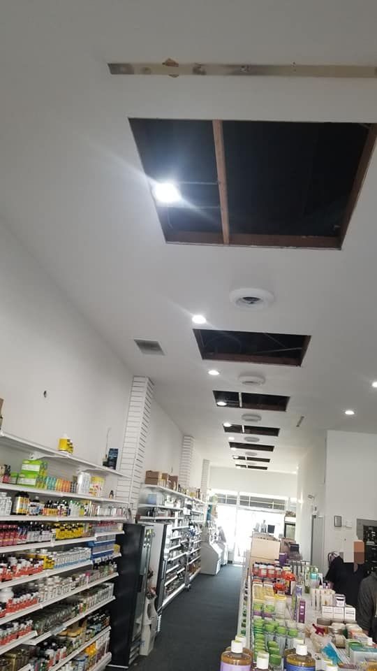The inside of a pharmacy with a hole in the ceiling.