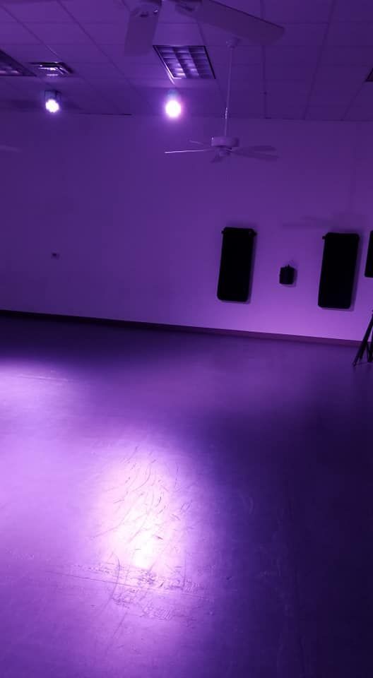 A purple room with a purple floor and purple lights on the ceiling.