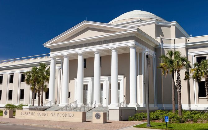 Florida Supreme Court building with white columns, dome, and blue sky.