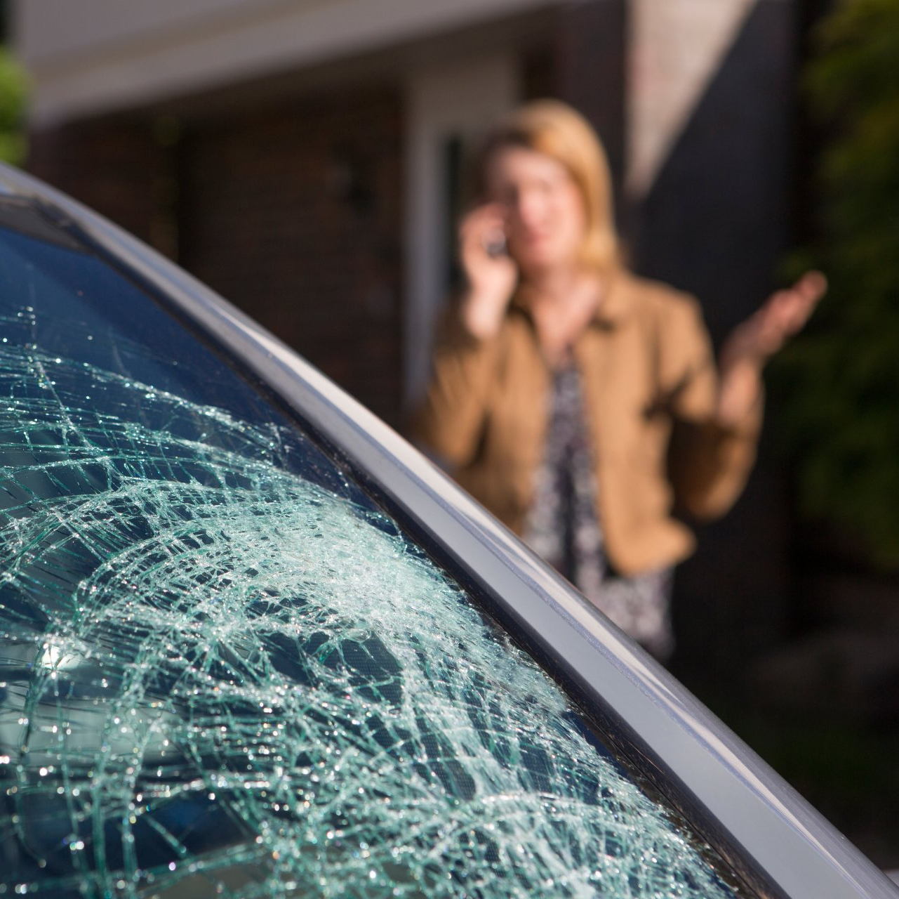 woman calling talking on the phone regarding broken windshield