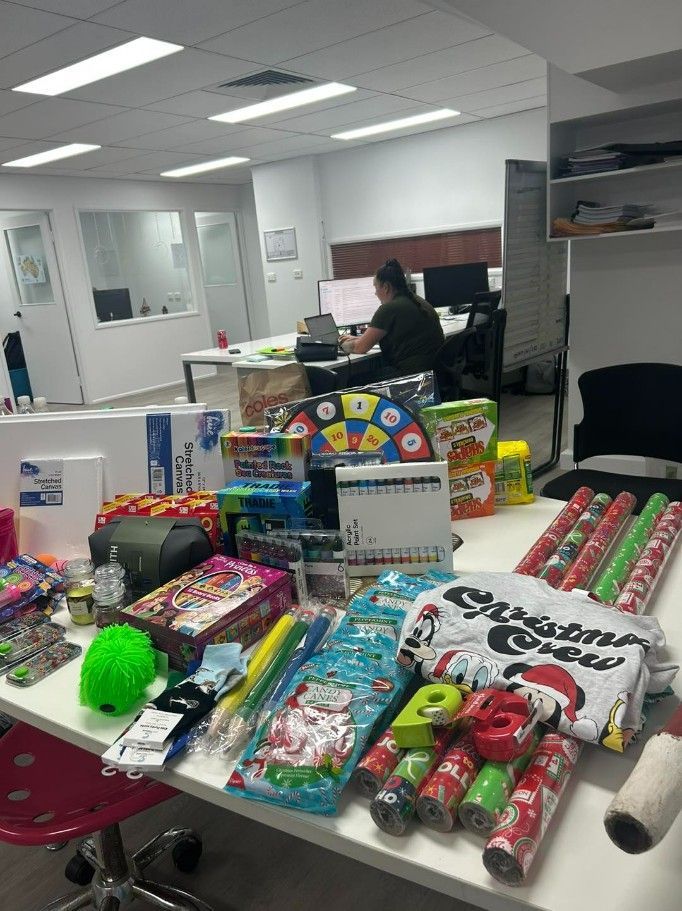 A Desk Filled With Lots of Toys and Wrapping Paper in an Office — Specialist Support Solutions in Rockhampton City, QLD