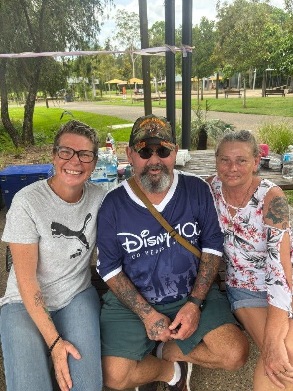 A Man and Two Women Are Posing for a Picture in a Park — Specialist Support Solutions in Gladstone, QLD