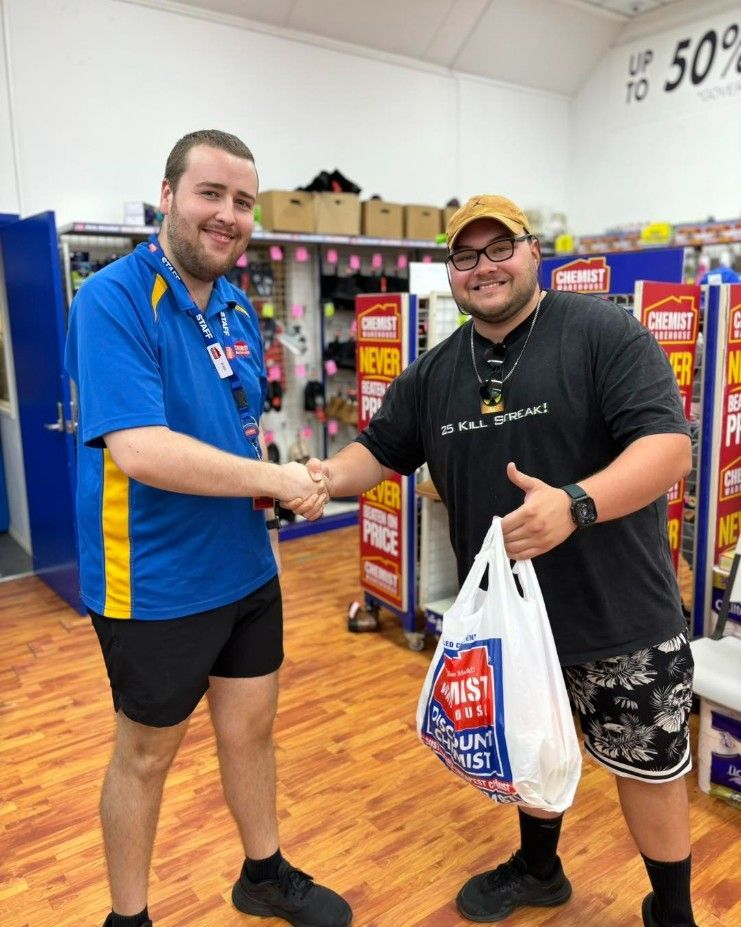 Two Men Are Shaking Hands in a Store — Specialist Support Solutions in Gladstone, QLD