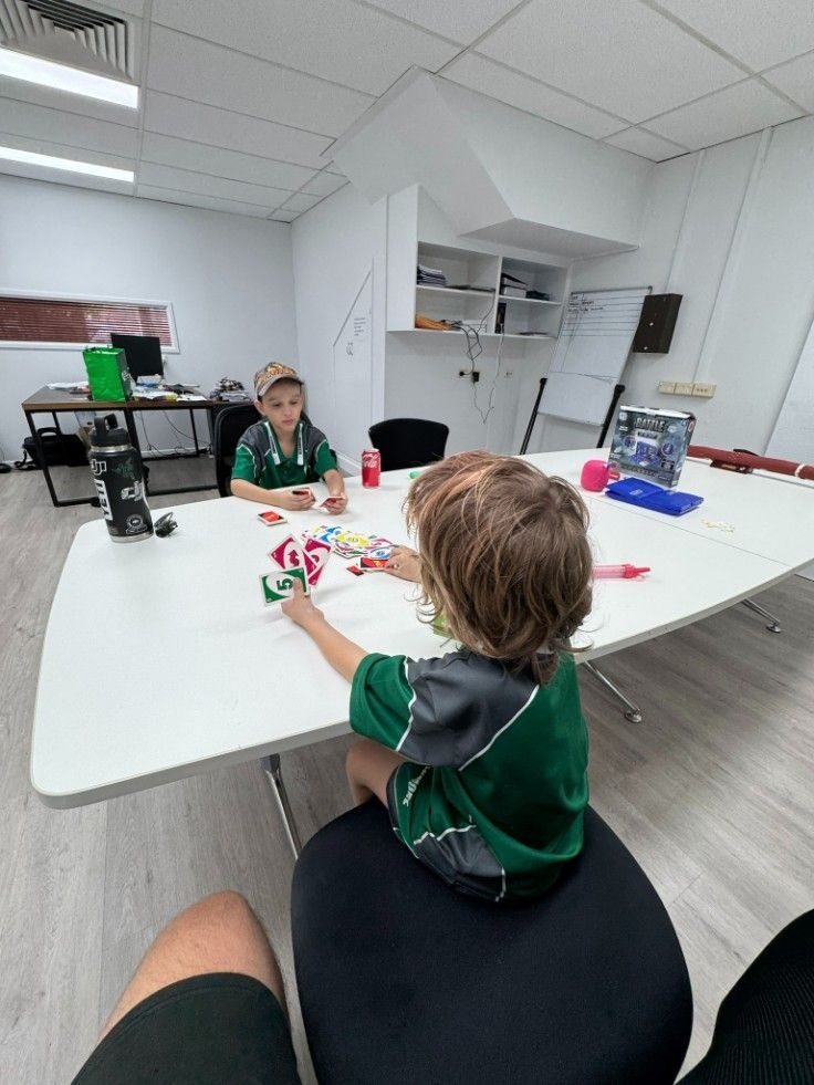A Group of Children Are Sitting at a Table in a Room — Specialist Support Solutions in Yeppoon, QLD