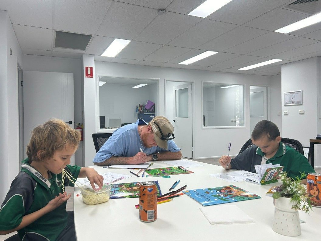 A Group of People Are Sitting Around a Table Painting — Specialist Support Solutions in Rockhampton City, QLD