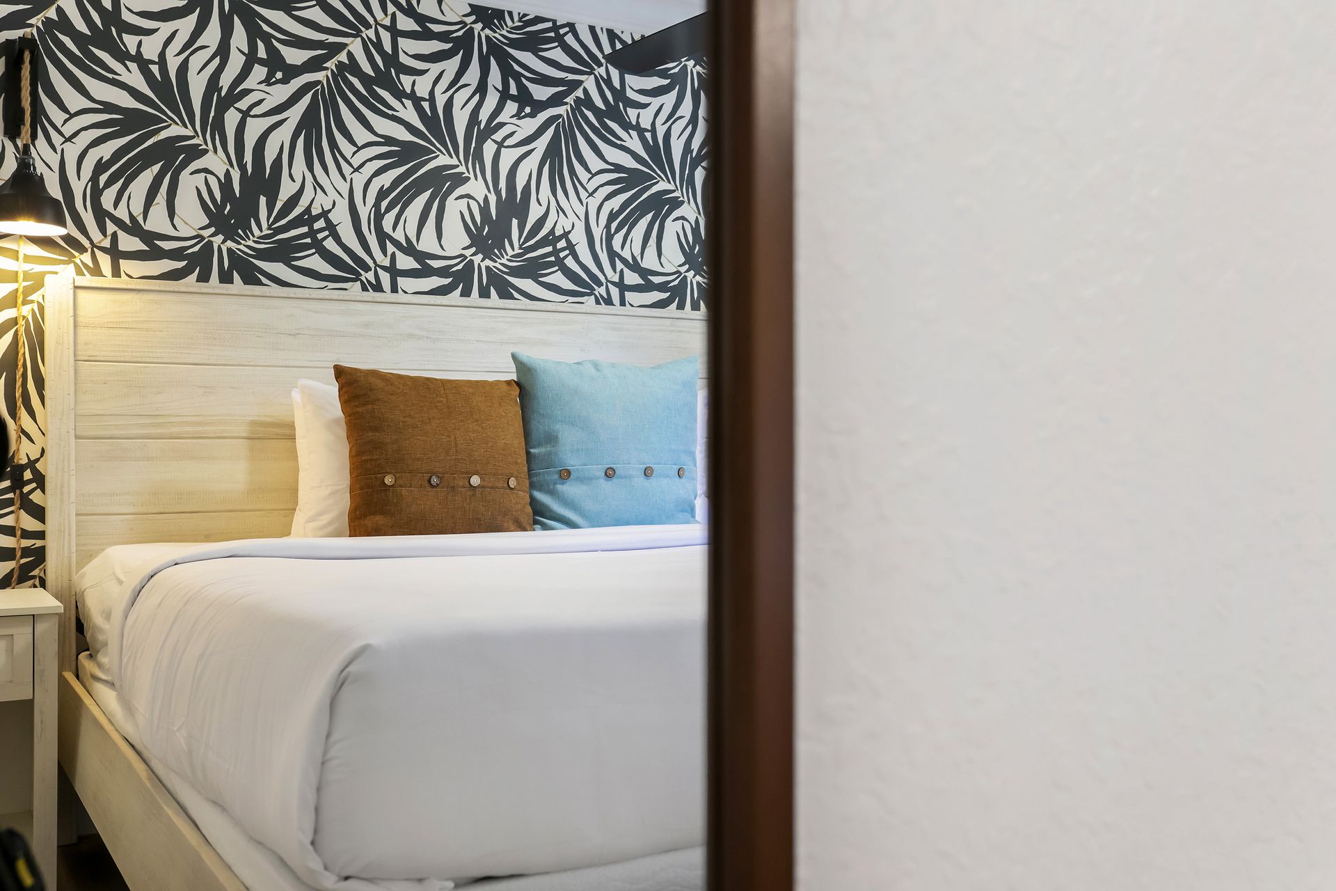 Bedroom interior with a bed, pillows, and a patterned wall.