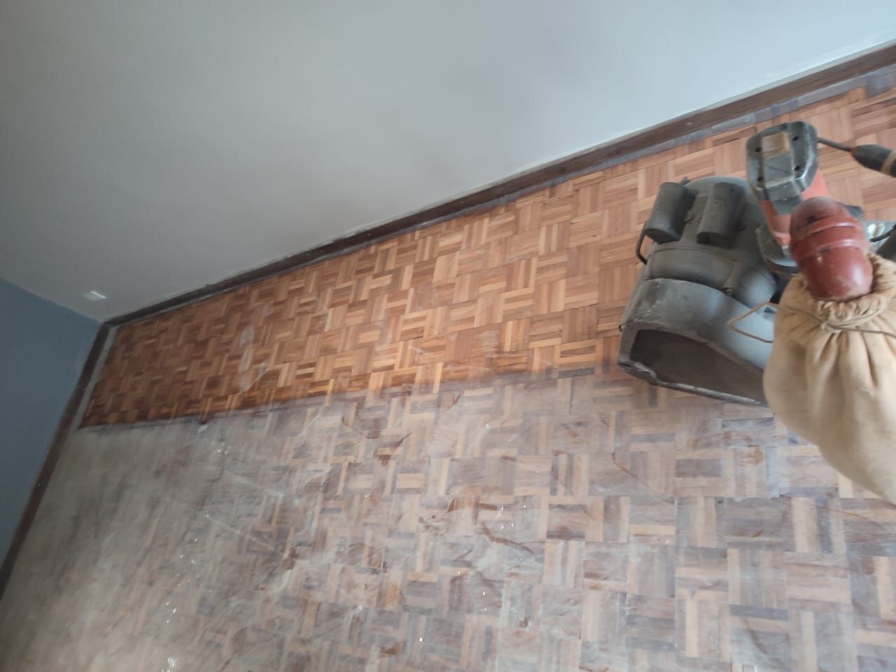 Persona lijando una pared de madera, quitando la capa superior y revelando una madera más clara debajo.