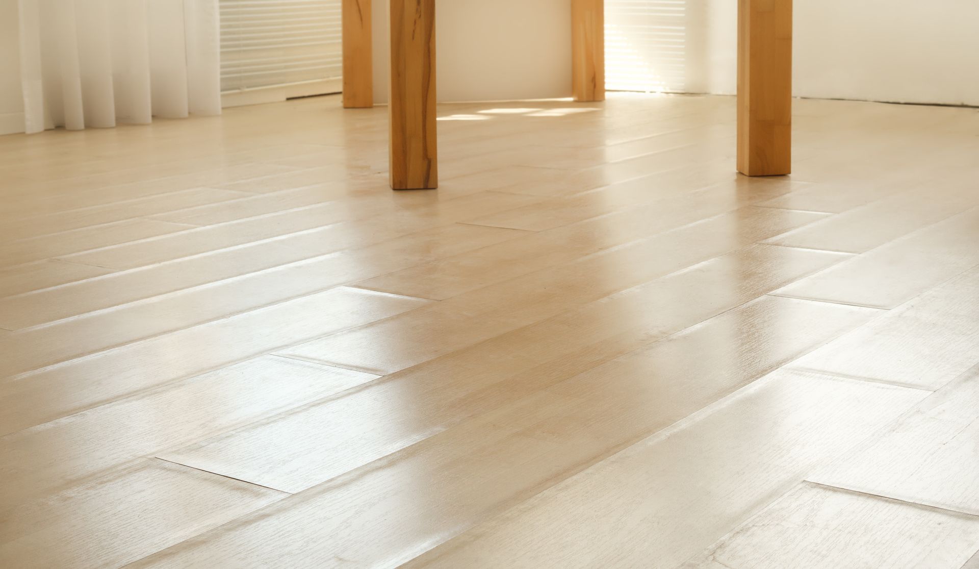 Light wood floor beneath a table with wooden legs in a bright room Light wood floor beneath a table with wooden legs in a bright room