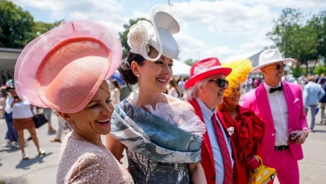 A group of people wearing hats and dresses are standing next to each other.