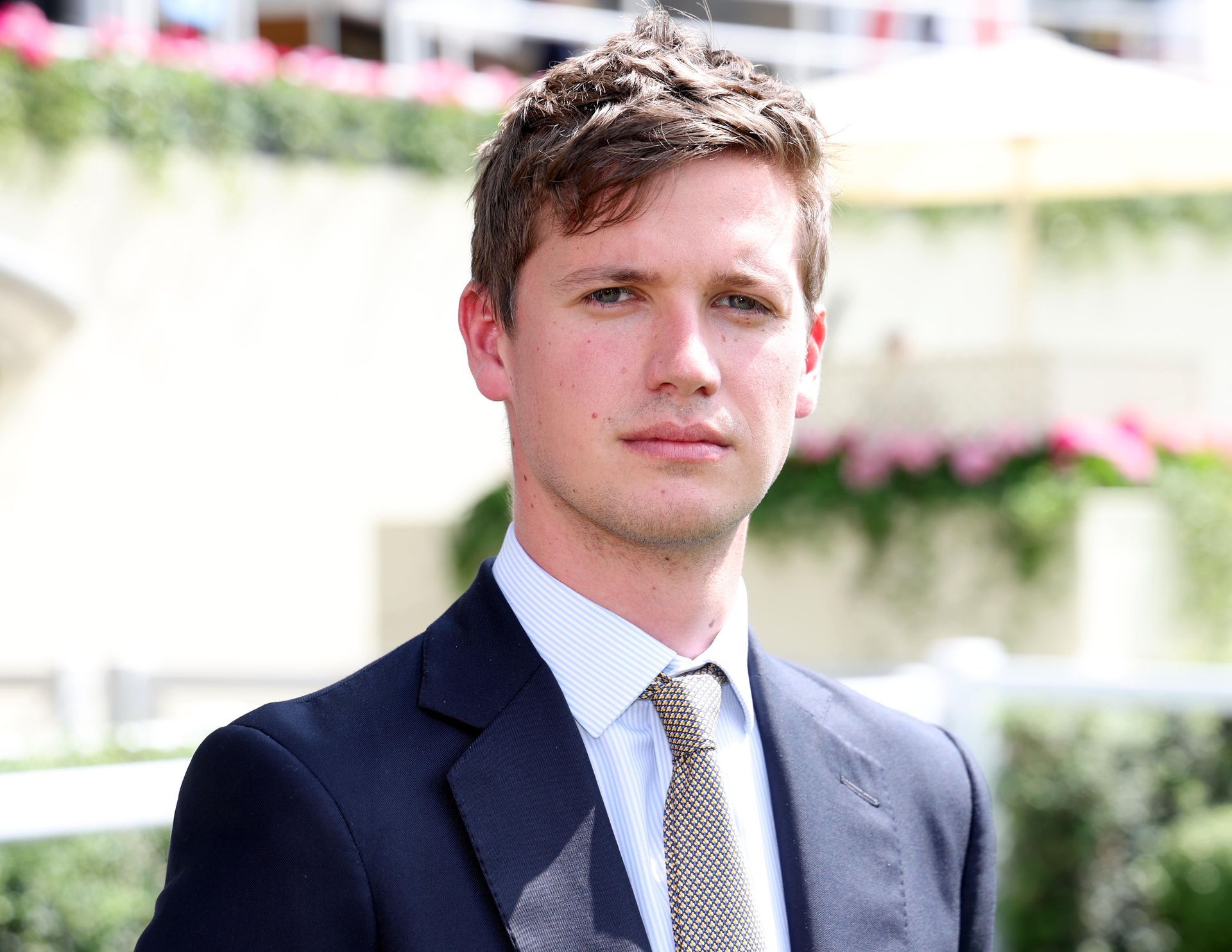 A man in a suit and tie is standing in front of a building.