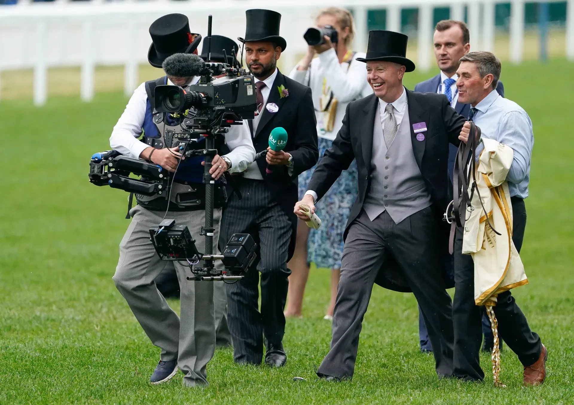 A group of men in top hats are walking on a grassy field.