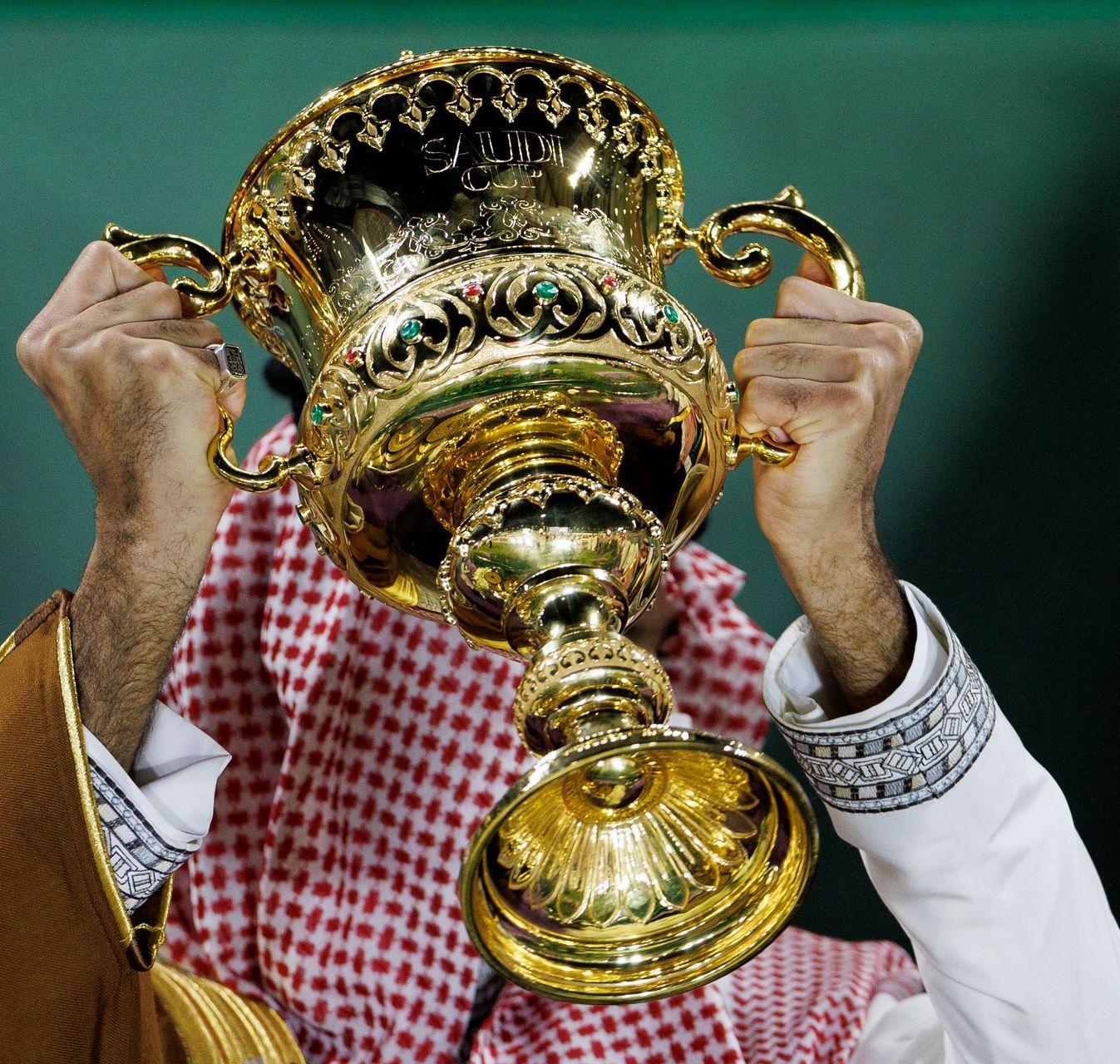 A man is holding a trophy in front of his face