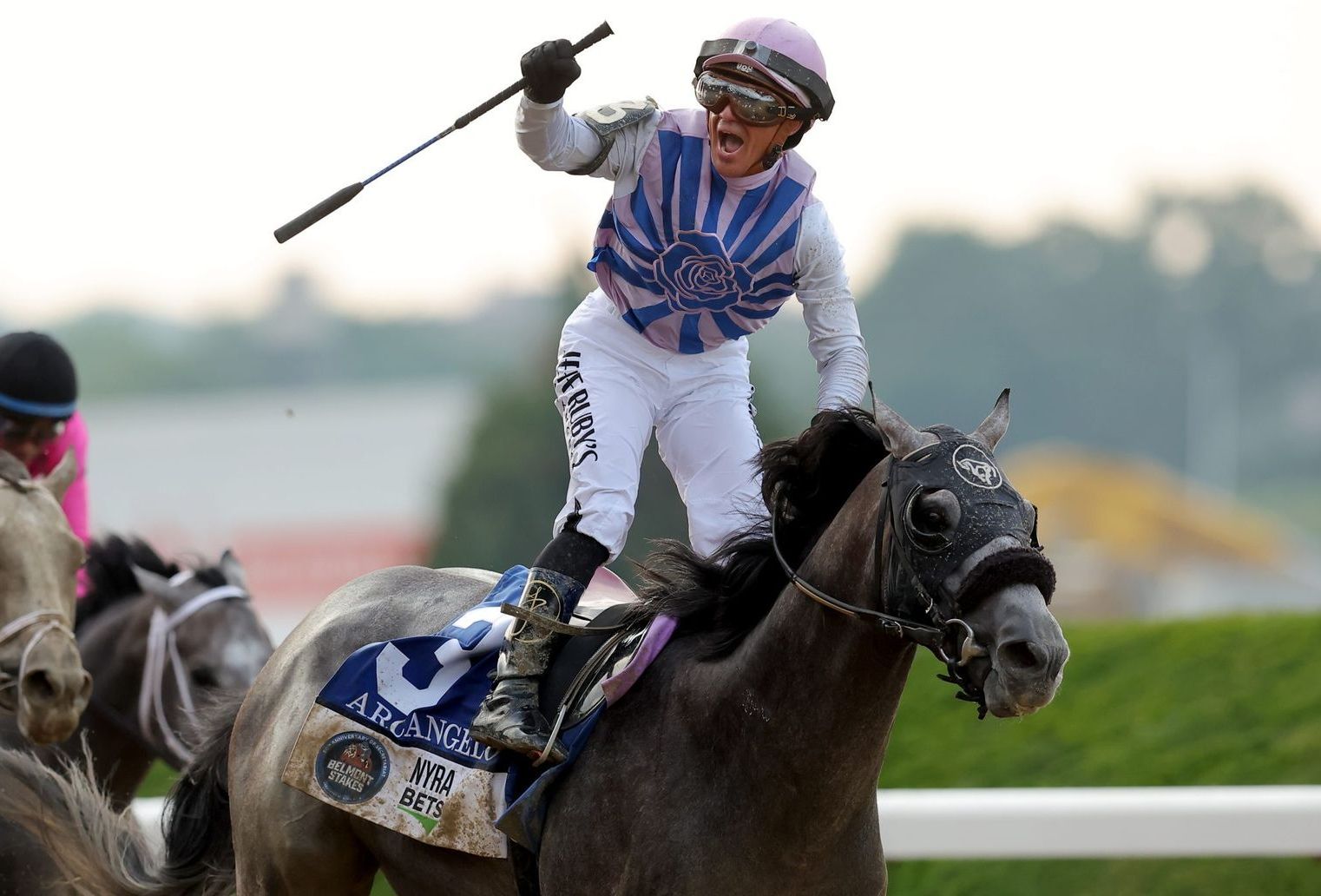 A jockey riding a horse with the number 3 on it