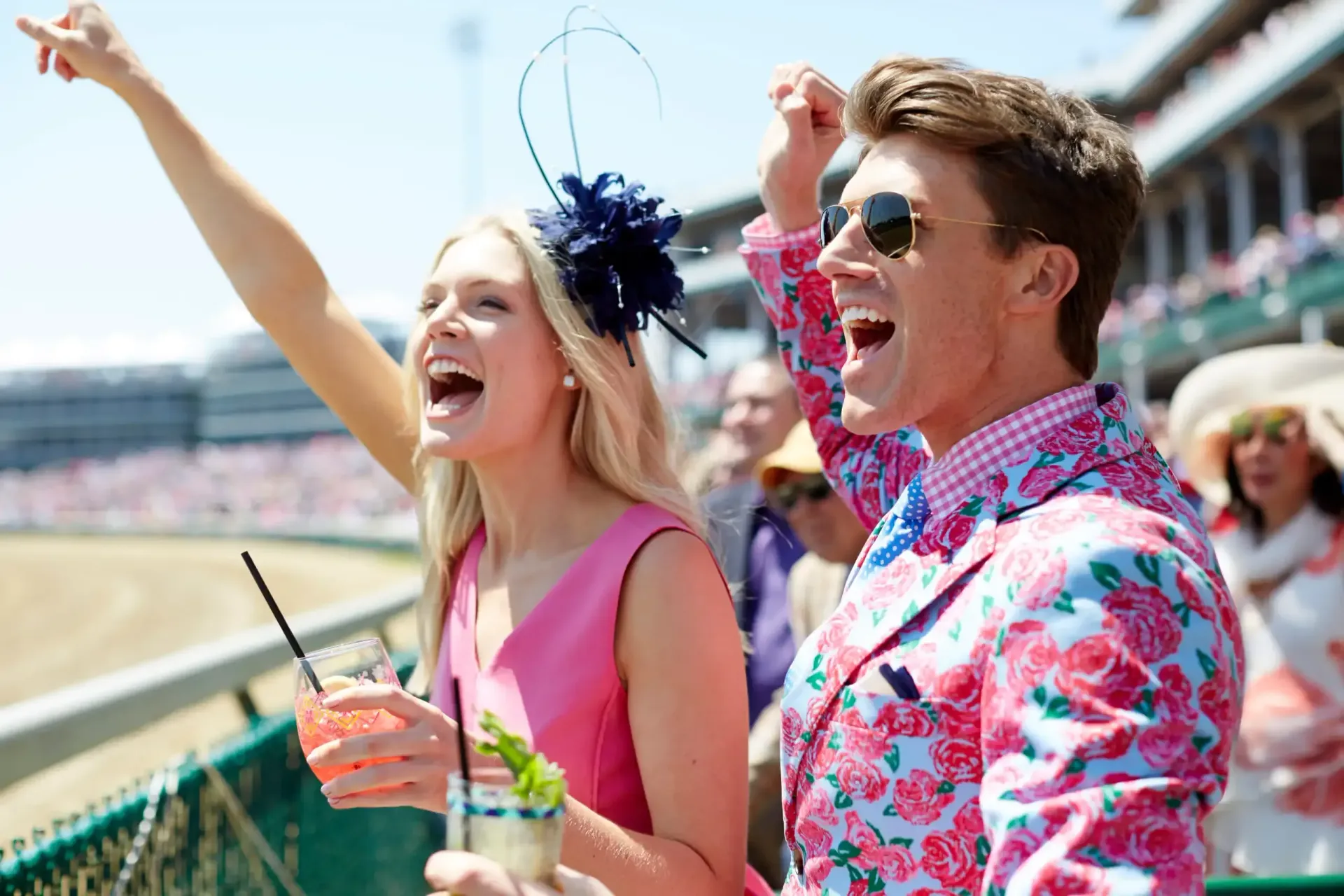 A man and a woman are standing next to each other at a race track.