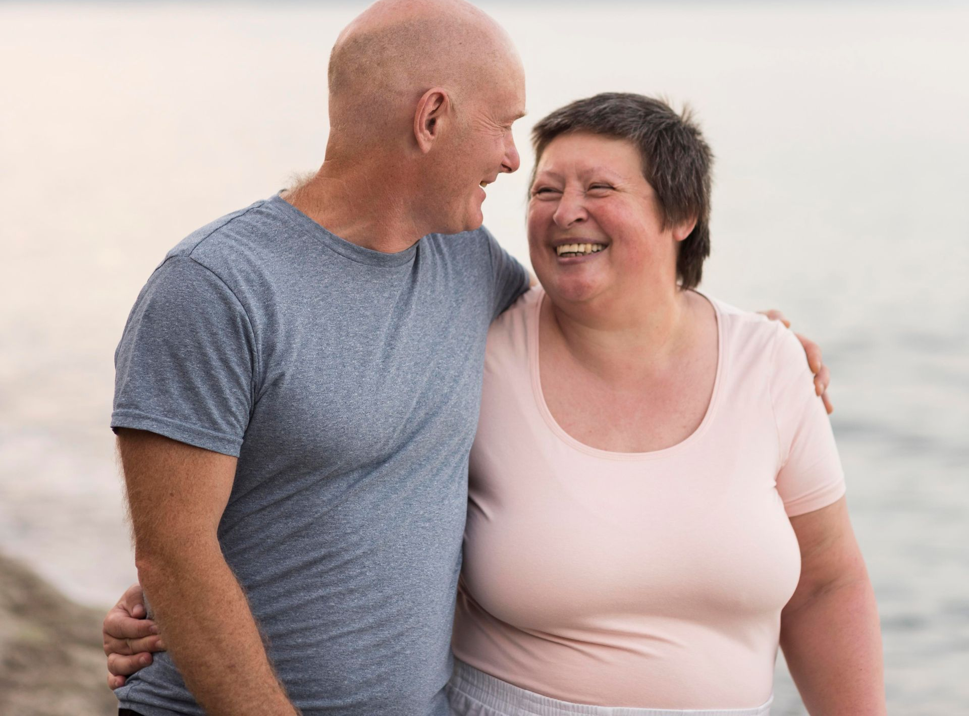 Woman in black bra and pants, measuring waist with a tape measure.