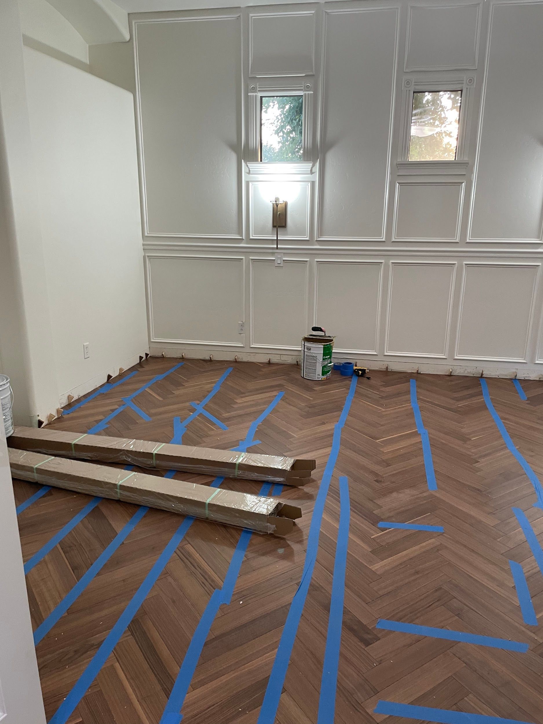 A room with a wooden floor and blue tape on it