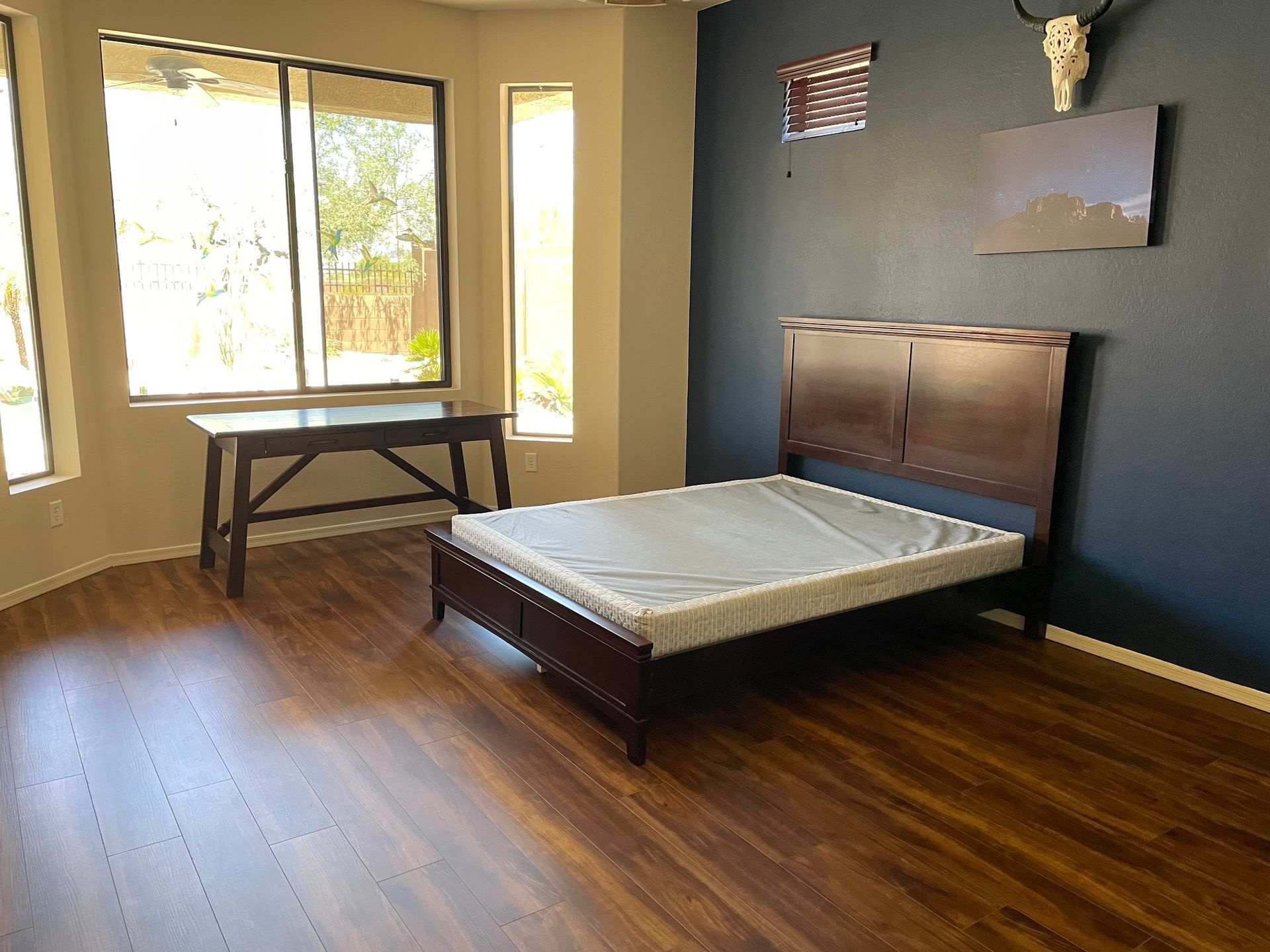 A bedroom with a bed , desk , and window.