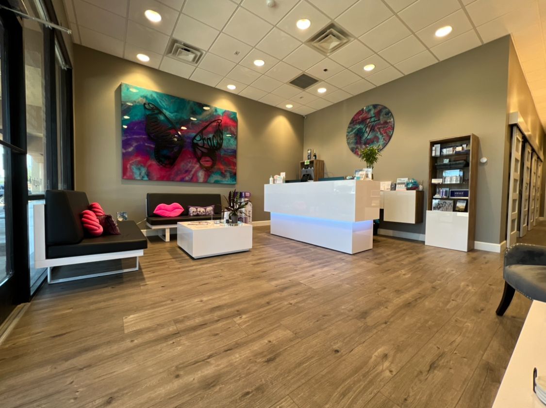 A waiting room with a white counter and a painting on the wall.