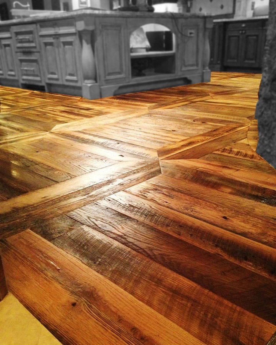 A person is standing on a wooden floor in a kitchen.